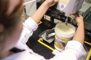 female worker doing quality check on mayonnaise machine