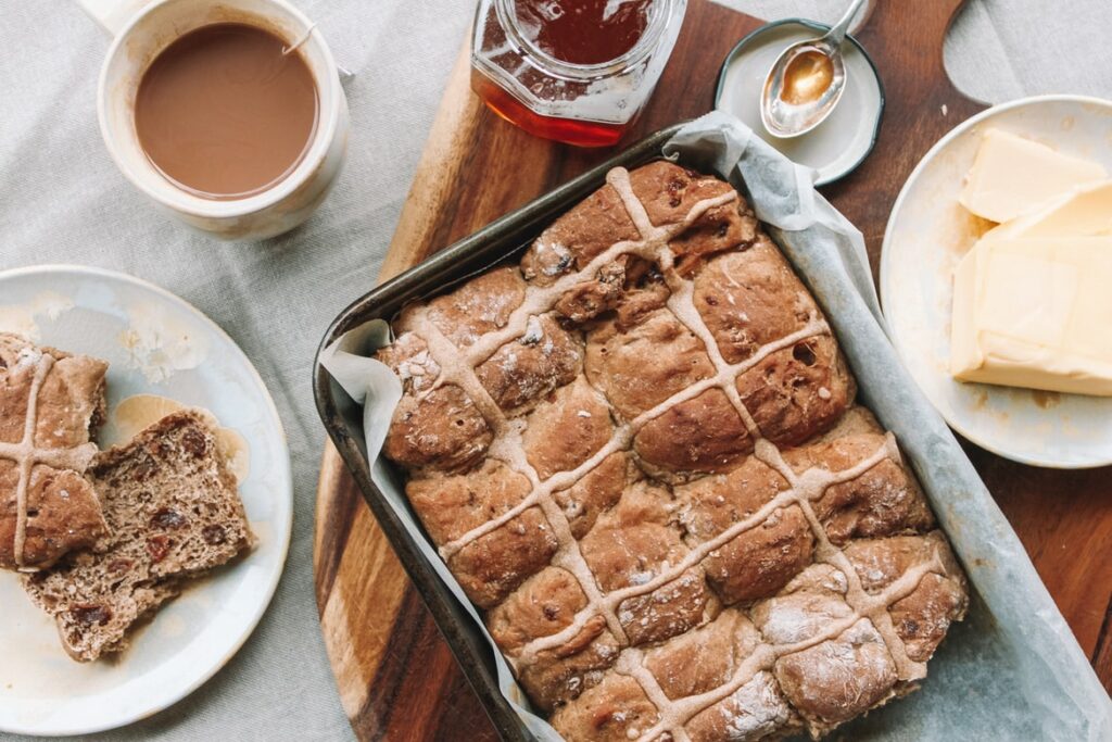 freshly baked pastry, hot tea, honey, and butter on the table