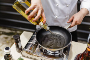 chef preparing olive oil in a pan