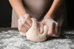 Female hands making dough
