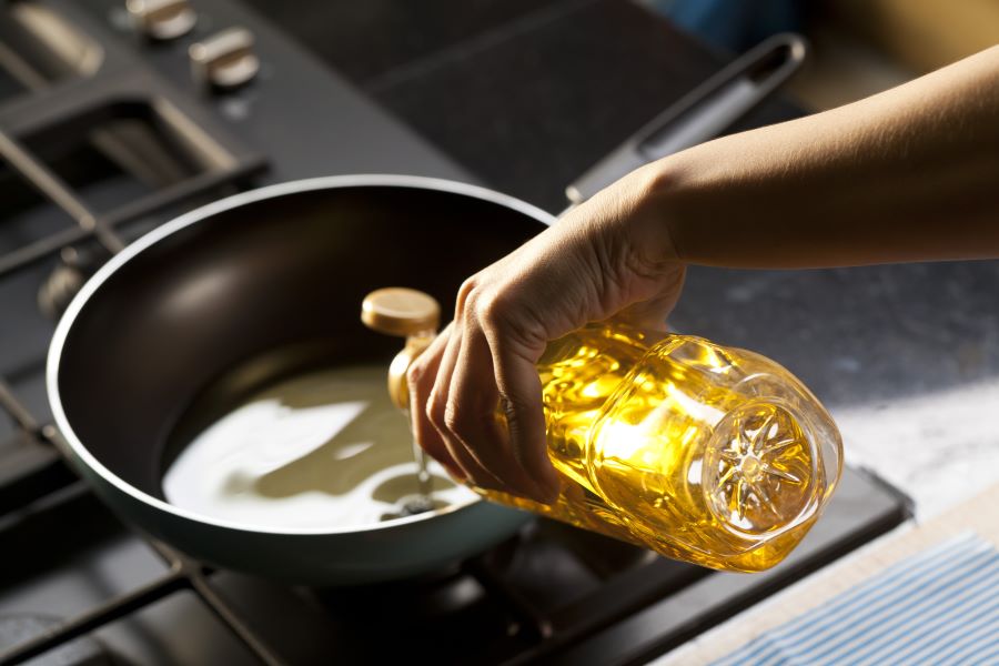 pouring oil into a pan