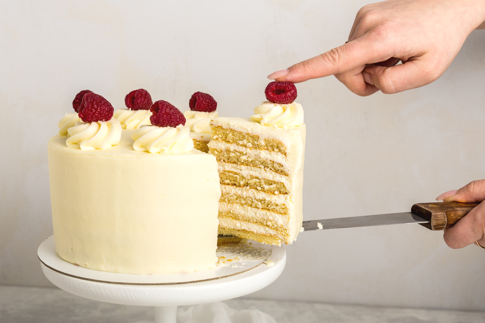 white cake with raspberries on top