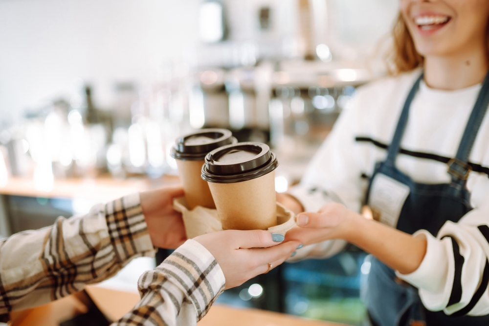 a barista handing out two coffees