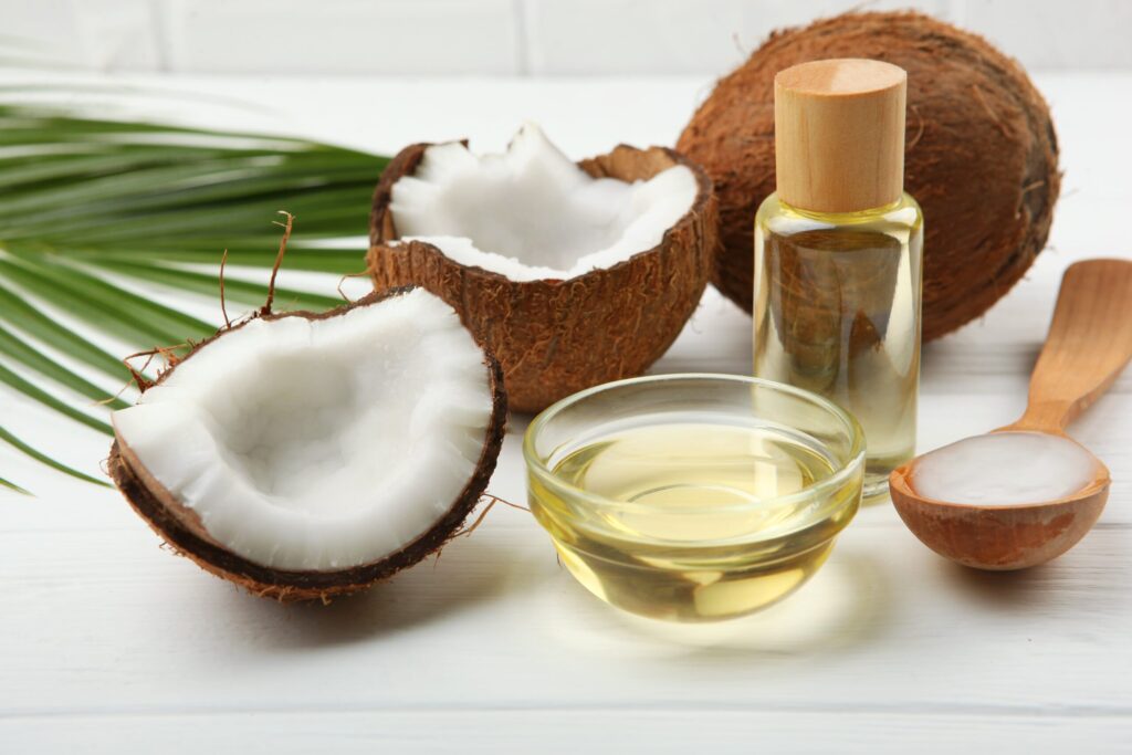 coconut oil on a bottle with open coconuts