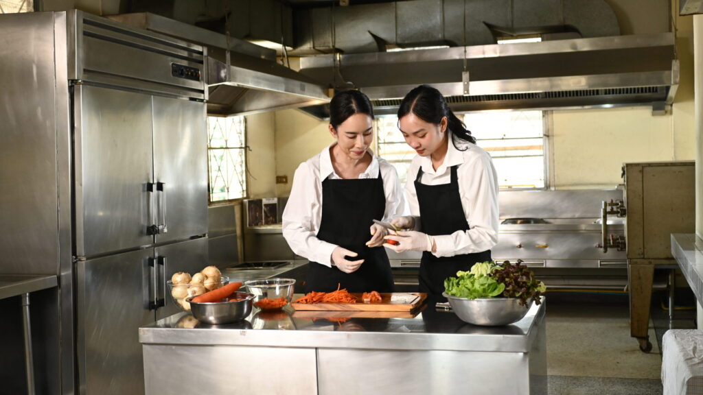 two kitchen staff preparing food