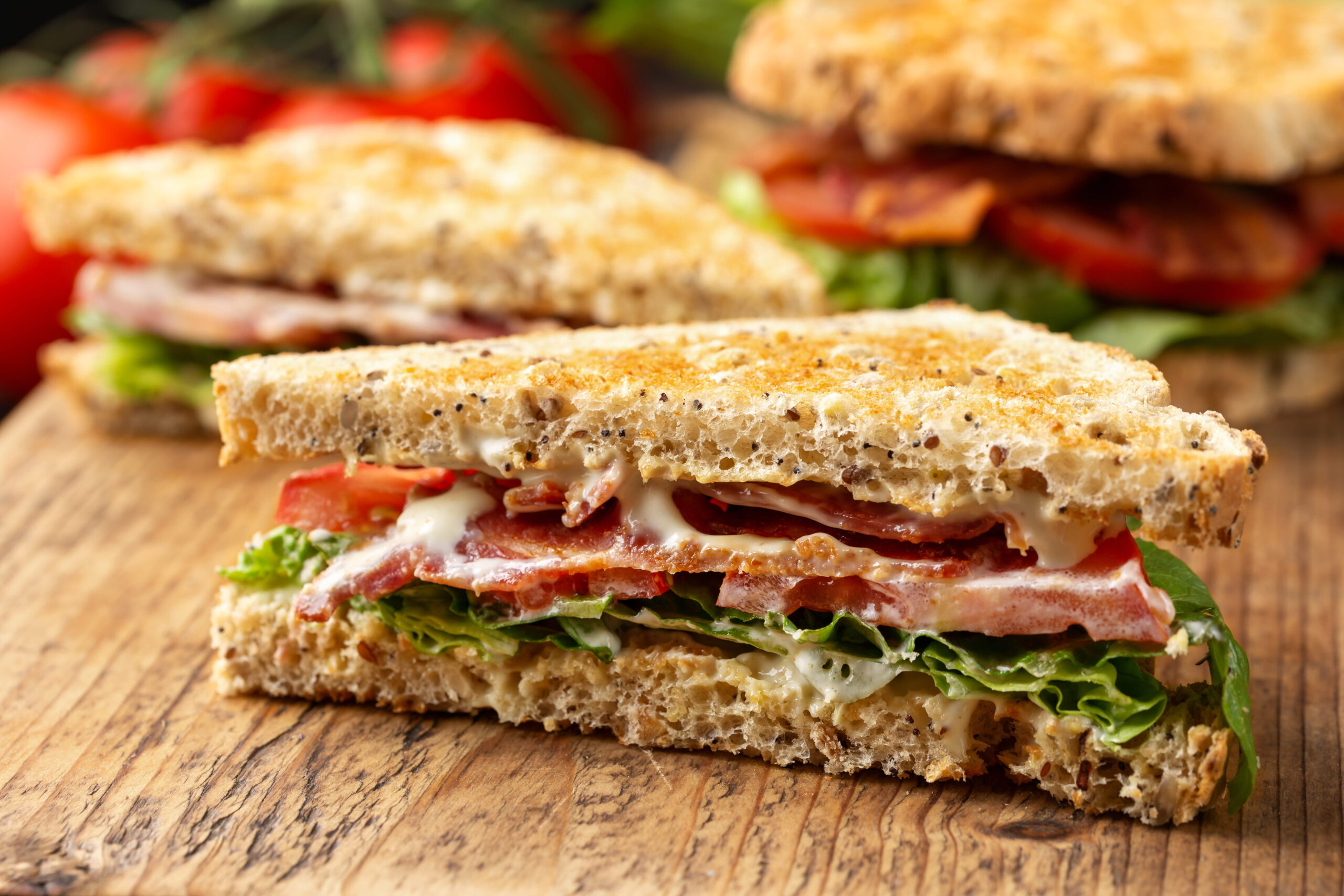 fresh BLT sandwich with bacon lettuce and tomato on wooden board