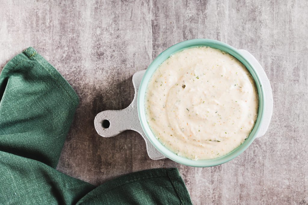 Close up of ranch dressing made with cottage cheese and pickles in a bowl top view
