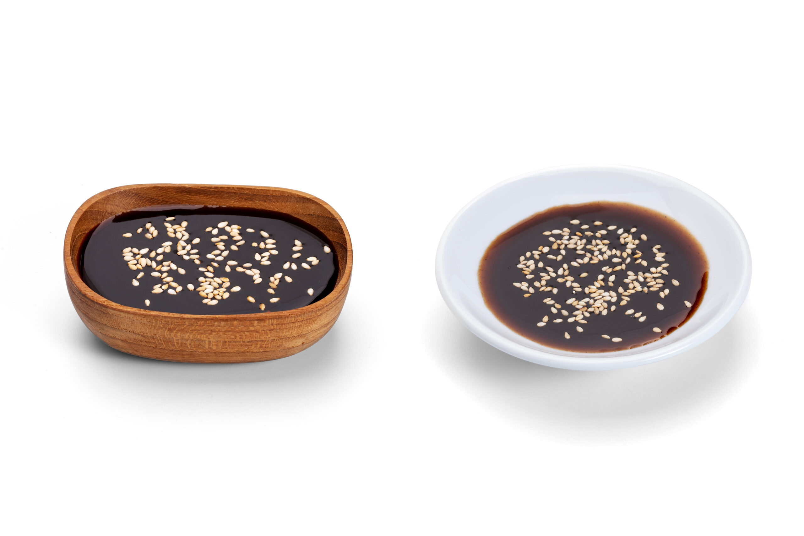 tonkatsu dipping sauce sprinkled with white sesame seeds isolated on white background