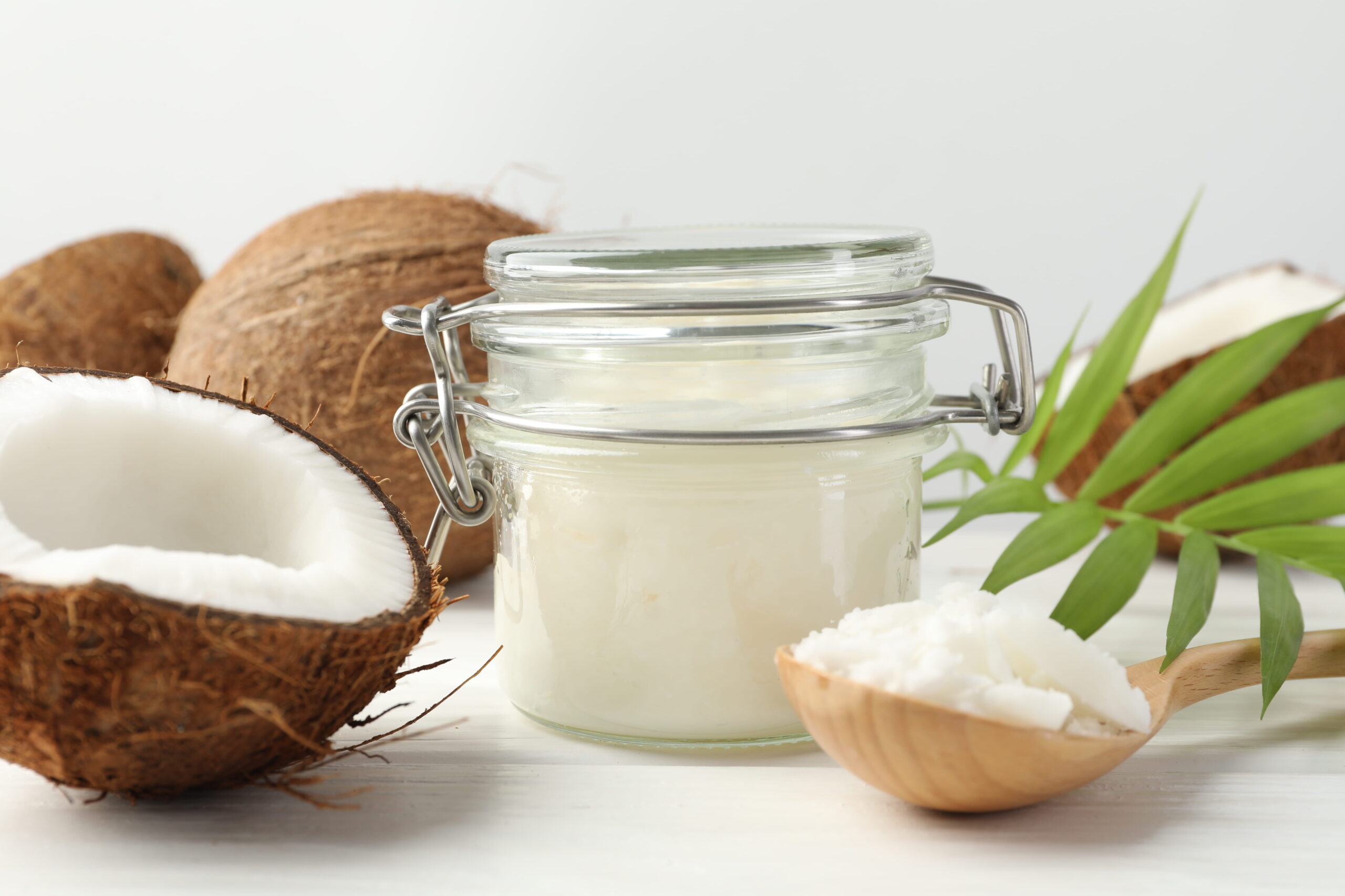 coconut cooking oil in jar on white wooden table