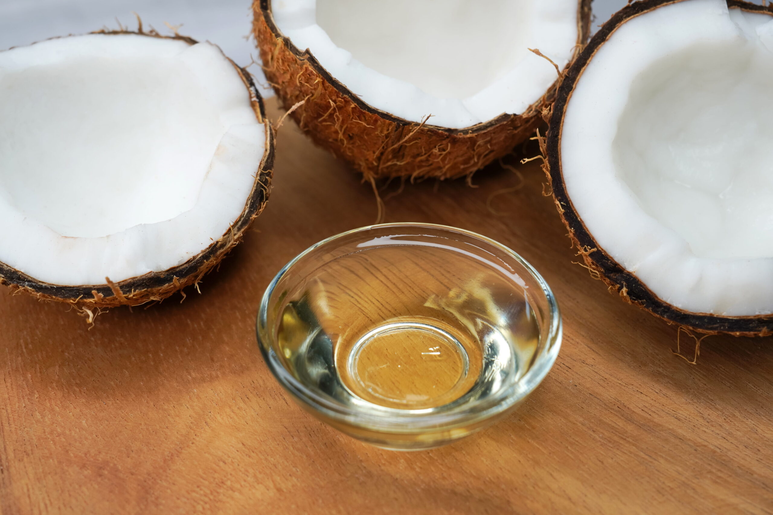 coconut oil in glass jar with coconut cut open in half
